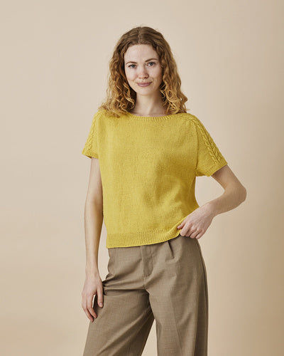Strikket t-shirt med sadelskuldre og snoninger på ærmer. Strikket i Esther by Permin i farven solgul. Strikkeopskrift nr 8934127